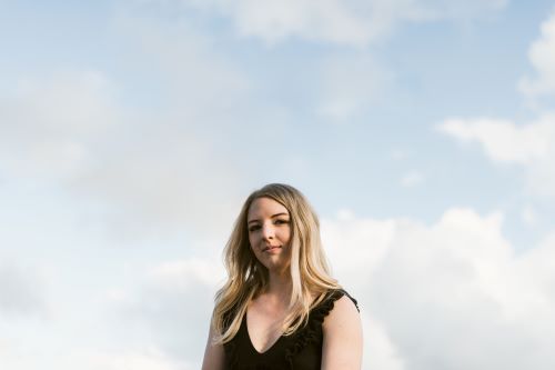 Jessica standing with clouds above her